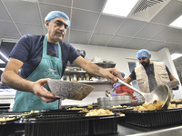 Lebanese volunteers prepare food portions for displaced people at Father Hani Tawk's charitable facility, Mariam's Kitchen, in Beirut, Leban...