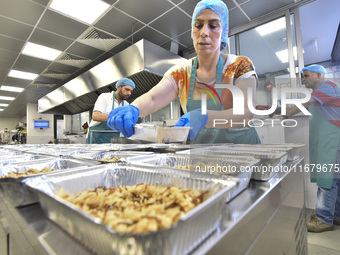 Lebanese volunteers prepare food portions for displaced people at Father Hani Tawk's charitable facility, Mariam's Kitchen, in Beirut, Leban...