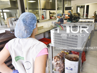 Lebanese volunteers prepare food portions for displaced people at Father Hani Tawk's charitable facility, Mariam's Kitchen, in Beirut, Leban...