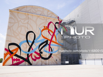 A moment of the press presentation of the mural Waves Only Exist Because the Wind Blows by eL Seed on the exterior walls of Pirelli HangarBi...