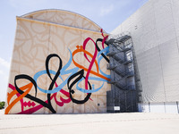 A moment of the press presentation of the mural Waves Only Exist Because the Wind Blows by eL Seed on the exterior walls of Pirelli HangarBi...