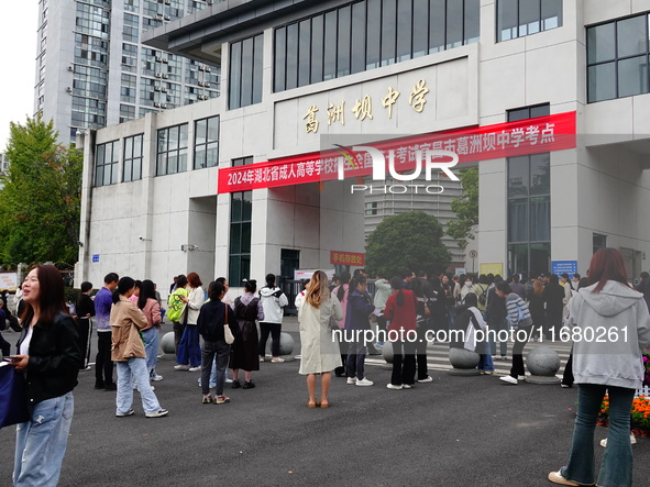 Candidates queue to enter the exam room during the 2024 National Adult College Entrance Examination in Yichang, Hubei province, China, on Oc...