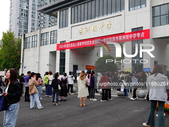 Candidates queue to enter the exam room during the 2024 National Adult College Entrance Examination in Yichang, Hubei province, China, on Oc...