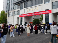 Candidates queue to enter the exam room during the 2024 National Adult College Entrance Examination in Yichang, Hubei province, China, on Oc...