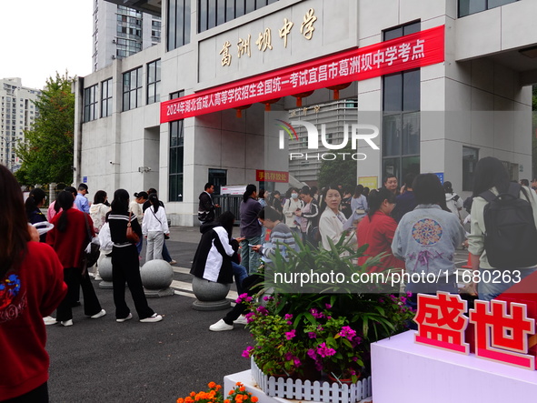 Candidates queue to enter the exam room during the 2024 National Adult College Entrance Examination in Yichang, Hubei province, China, on Oc...