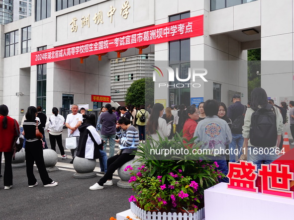 Candidates queue to enter the exam room during the 2024 National Adult College Entrance Examination in Yichang, Hubei province, China, on Oc...