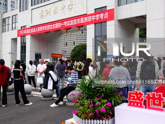 Candidates queue to enter the exam room during the 2024 National Adult College Entrance Examination in Yichang, Hubei province, China, on Oc...