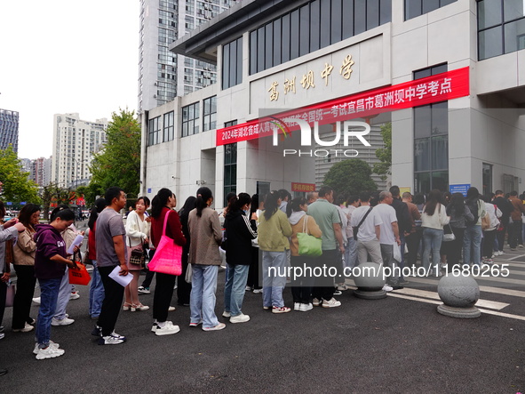 Candidates queue to enter the exam room during the 2024 National Adult College Entrance Examination in Yichang, Hubei province, China, on Oc...