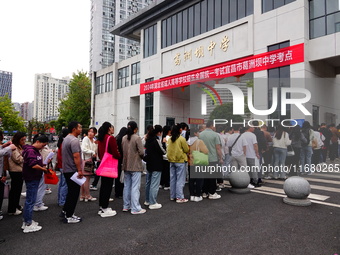 Candidates queue to enter the exam room during the 2024 National Adult College Entrance Examination in Yichang, Hubei province, China, on Oc...