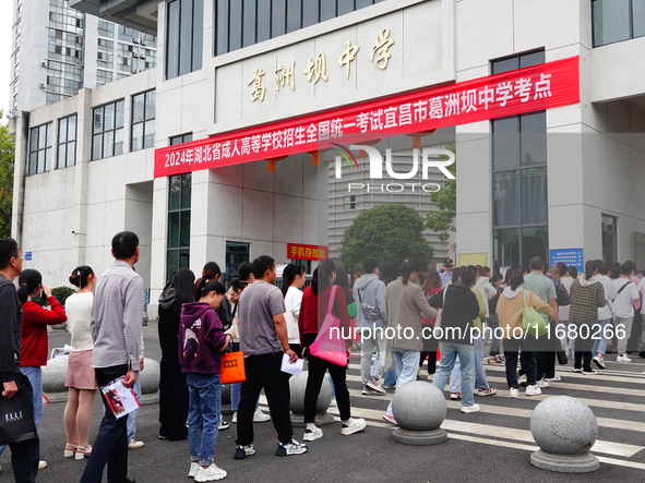 Candidates queue to enter the exam room during the 2024 National Adult College Entrance Examination in Yichang, Hubei province, China, on Oc...