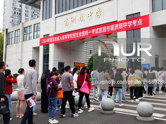 Candidates queue to enter the exam room during the 2024 National Adult College Entrance Examination in Yichang, Hubei province, China, on Oc...