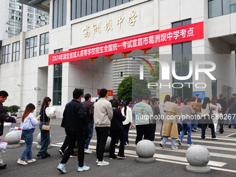 Candidates queue to enter the exam room during the 2024 National Adult College Entrance Examination in Yichang, Hubei province, China, on Oc...