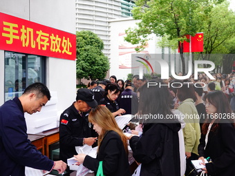 Candidates queue to enter the exam room during the 2024 National Adult College Entrance Examination in Yichang, Hubei province, China, on Oc...