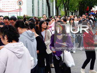 Candidates queue to enter the exam room during the 2024 National Adult College Entrance Examination in Yichang, Hubei province, China, on Oc...