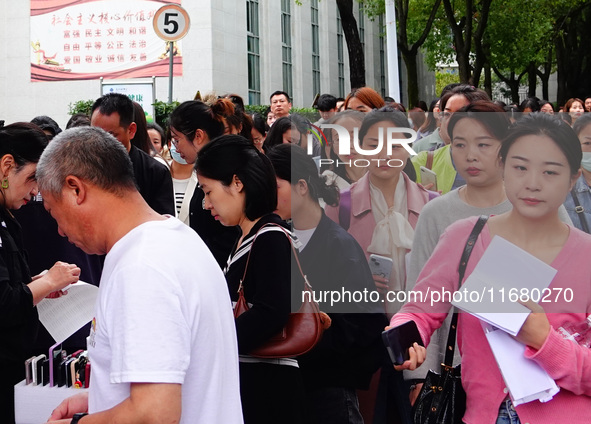 Candidates queue to enter the exam room during the 2024 National Adult College Entrance Examination in Yichang, Hubei province, China, on Oc...