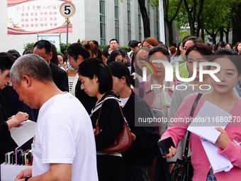 Candidates queue to enter the exam room during the 2024 National Adult College Entrance Examination in Yichang, Hubei province, China, on Oc...