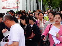 Candidates queue to enter the exam room during the 2024 National Adult College Entrance Examination in Yichang, Hubei province, China, on Oc...