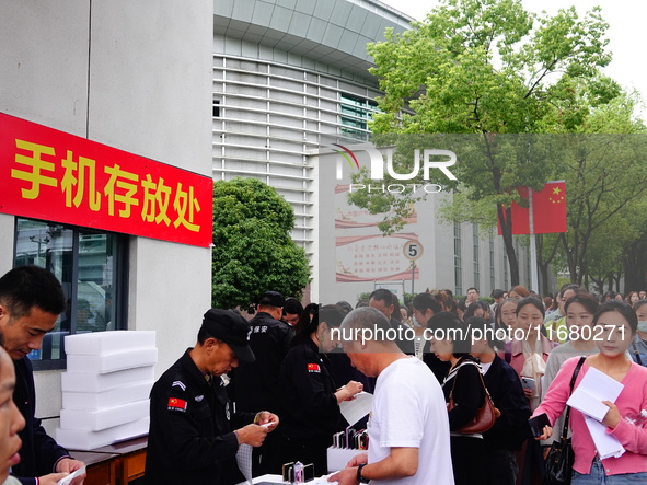 Candidates queue to enter the exam room during the 2024 National Adult College Entrance Examination in Yichang, Hubei province, China, on Oc...