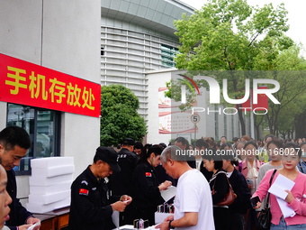 Candidates queue to enter the exam room during the 2024 National Adult College Entrance Examination in Yichang, Hubei province, China, on Oc...