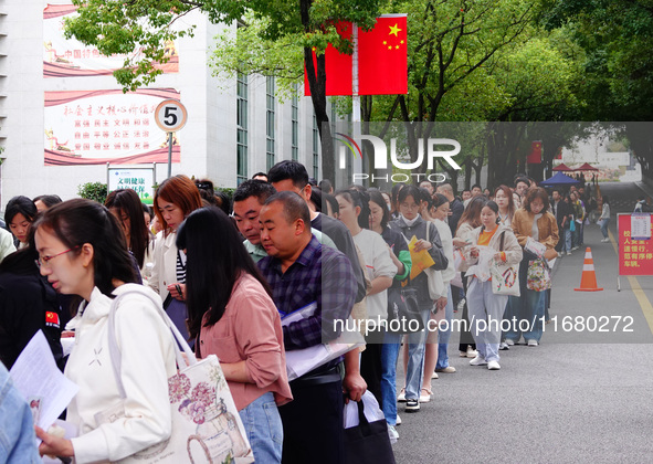 Candidates queue to enter the exam room during the 2024 National Adult College Entrance Examination in Yichang, Hubei province, China, on Oc...