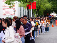 Candidates queue to enter the exam room during the 2024 National Adult College Entrance Examination in Yichang, Hubei province, China, on Oc...