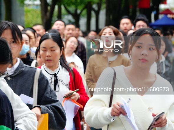 Candidates queue to enter the exam room during the 2024 National Adult College Entrance Examination in Yichang, Hubei province, China, on Oc...