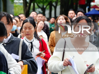 Candidates queue to enter the exam room during the 2024 National Adult College Entrance Examination in Yichang, Hubei province, China, on Oc...