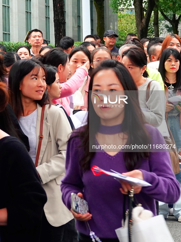 Candidates queue to enter the exam room during the 2024 National Adult College Entrance Examination in Yichang, Hubei province, China, on Oc...