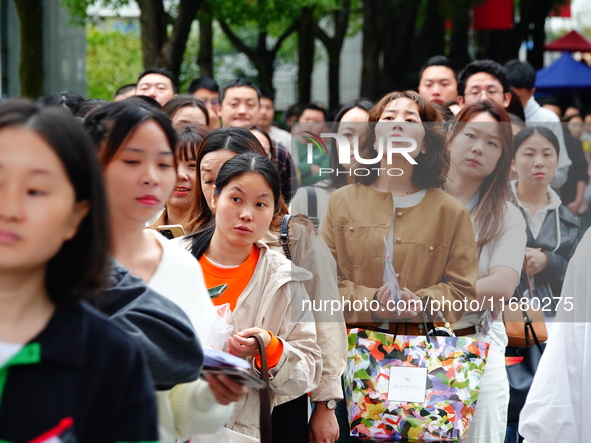 Candidates queue to enter the exam room during the 2024 National Adult College Entrance Examination in Yichang, Hubei province, China, on Oc...