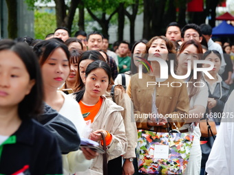 Candidates queue to enter the exam room during the 2024 National Adult College Entrance Examination in Yichang, Hubei province, China, on Oc...