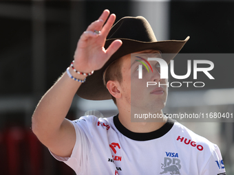 Liam Lawson wears a cowboy hat as he walks through the paddock at Circuit of the Americas in Austin, Texas, on October 18, 2024, during the...