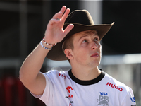 Liam Lawson wears a cowboy hat as he walks through the paddock at Circuit of the Americas in Austin, Texas, on October 18, 2024, during the...