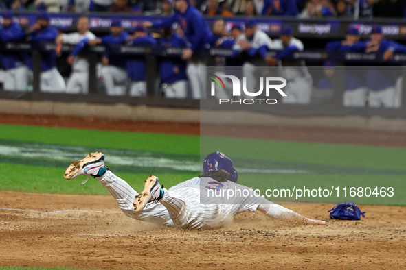 Jesse Winker #3 of the New York Mets scores on a sacrifice fly during the sixth inning in Game 5 of the baseball NL Championship Series agai...