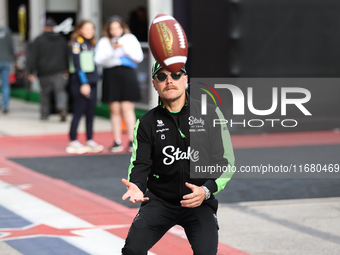 Valtteri Bottas attempts to catch an American football as he walks through the paddock at Circuit of the Americas in Austin, Texas, on Octob...