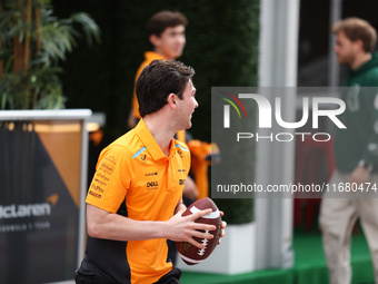 Pato O'Ward catches an American football as he walks through the paddock at Circuit of the Americas in Austin, Texas, on October 18, 2024, d...