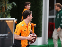 Pato O'Ward catches an American football as he walks through the paddock at Circuit of the Americas in Austin, Texas, on October 18, 2024, d...