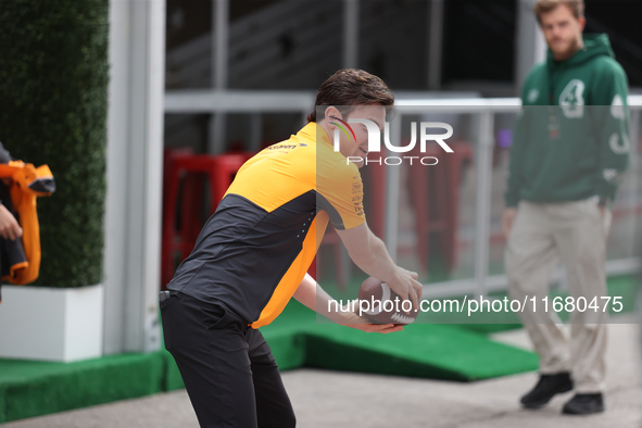 Pato O'Ward catches an American football as he walks through the paddock at Circuit of the Americas in Austin, Texas, on October 18, 2024, d...