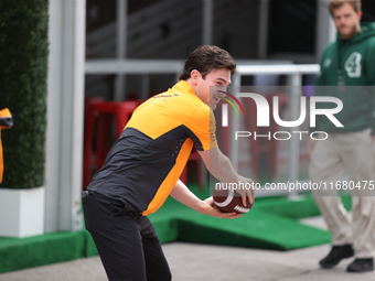 Pato O'Ward catches an American football as he walks through the paddock at Circuit of the Americas in Austin, Texas, on October 18, 2024, d...