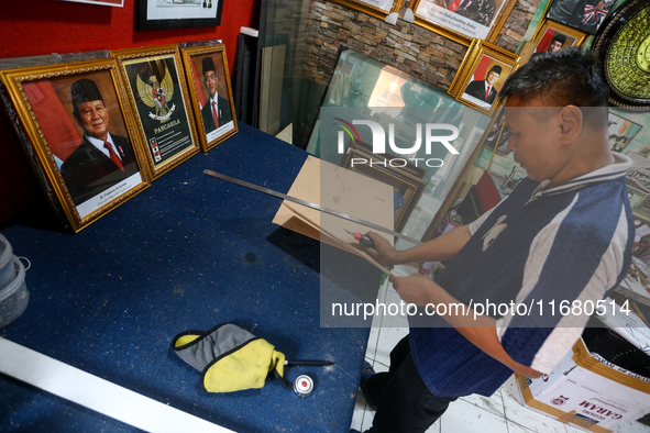 Workers make photo frames of the President-elect of the Republic of Indonesia, Prabowo Subianto, and Vice President Gibran Rakabuming at Rum...