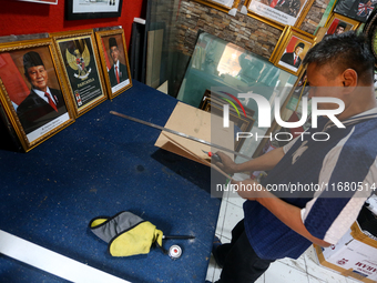 Workers make photo frames of the President-elect of the Republic of Indonesia, Prabowo Subianto, and Vice President Gibran Rakabuming at Rum...