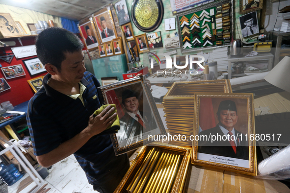 Workers make photo frames of the President-elect of the Republic of Indonesia, Prabowo Subianto, and Vice President Gibran Rakabuming at Rum...