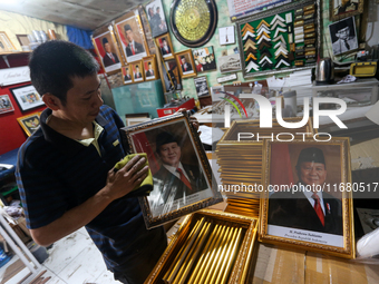 Workers make photo frames of the President-elect of the Republic of Indonesia, Prabowo Subianto, and Vice President Gibran Rakabuming at Rum...