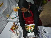 A pastry cook makes a tart with pictures of Indonesia's new president Prabowo Subianto and vice president Gibran Rakabuming Raka for the spe...