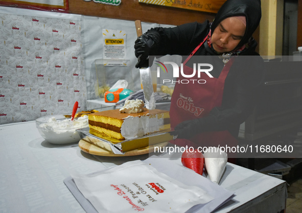 A pastry cook makes a tart with pictures of Indonesia's new president Prabowo Subianto and vice president Gibran Rakabuming Raka for the spe...