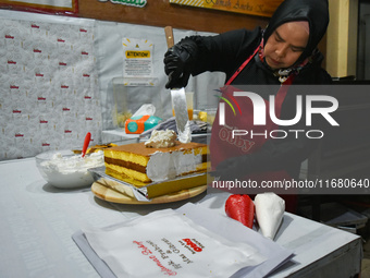 A pastry cook makes a tart with pictures of Indonesia's new president Prabowo Subianto and vice president Gibran Rakabuming Raka for the spe...