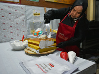 A pastry cook makes a tart with pictures of Indonesia's new president Prabowo Subianto and vice president Gibran Rakabuming Raka for the spe...