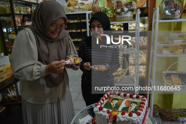 Visitors taste tarts with pictures of Indonesia's new president Prabowo Subianto and vice president Gibran Rakabuming Raka for the special e...