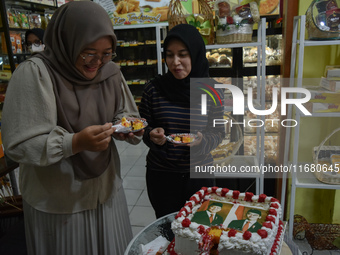 Visitors taste tarts with pictures of Indonesia's new president Prabowo Subianto and vice president Gibran Rakabuming Raka for the special e...