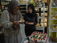 Visitors taste tarts with pictures of Indonesia's new president Prabowo Subianto and vice president Gibran Rakabuming Raka for the special e...