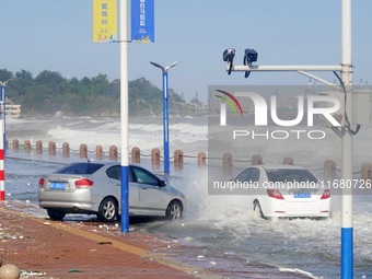 Cars pass a road covered with seawater at the seaside in Yantai, China, on October 19, 2024. (